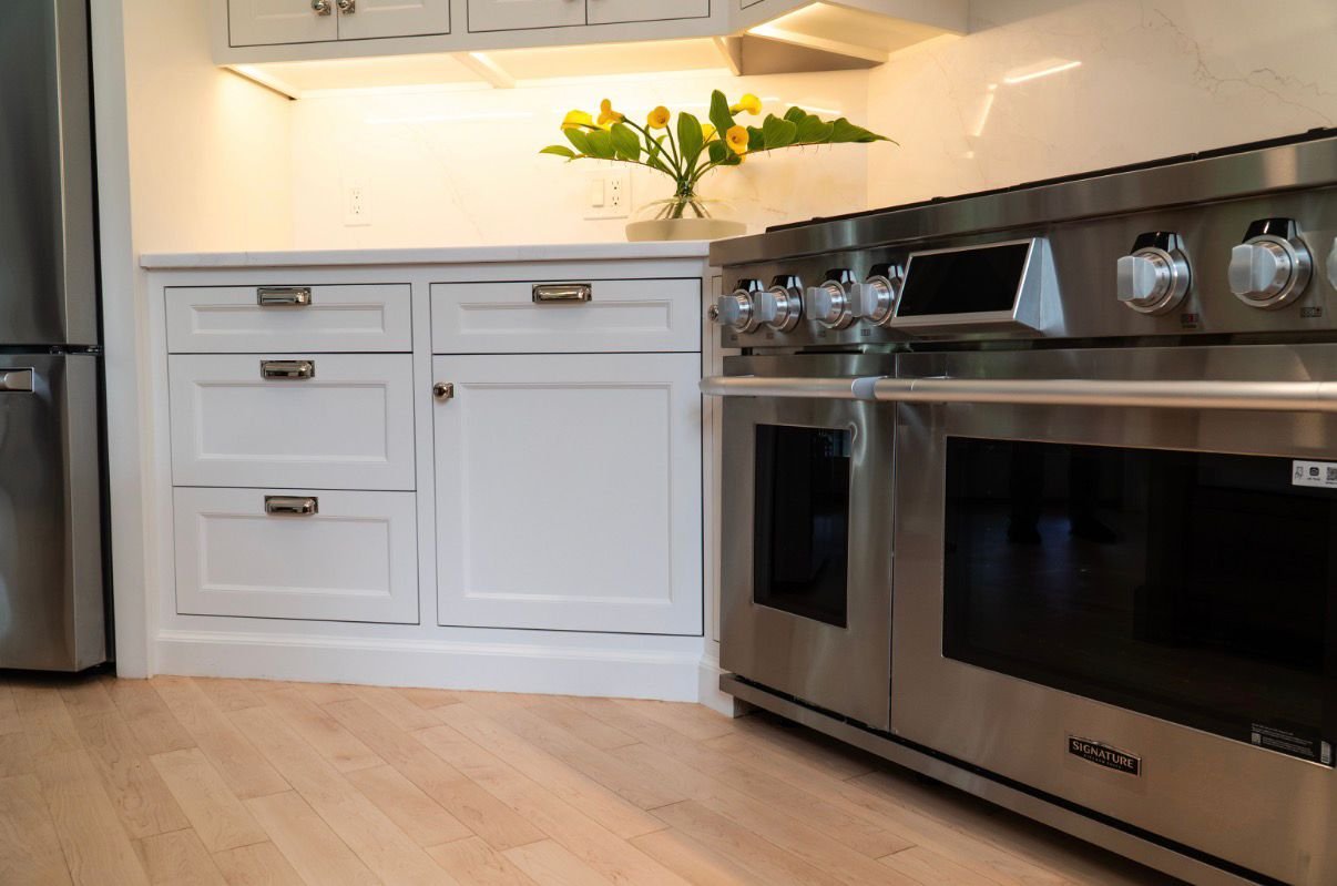Range wall with custom hood and white cabinetry