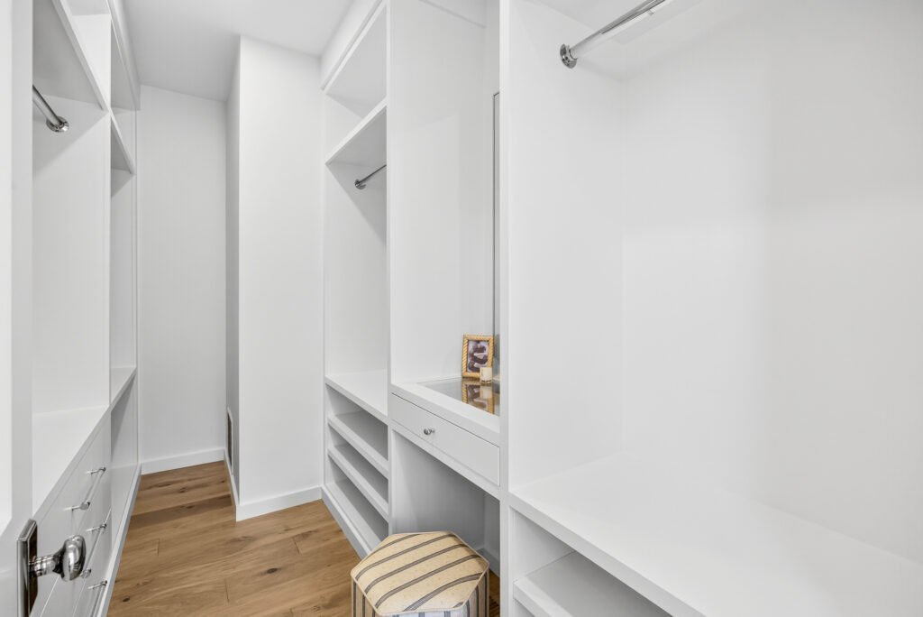 Primary bathroom with white double vanity, soaking tub and large mirror